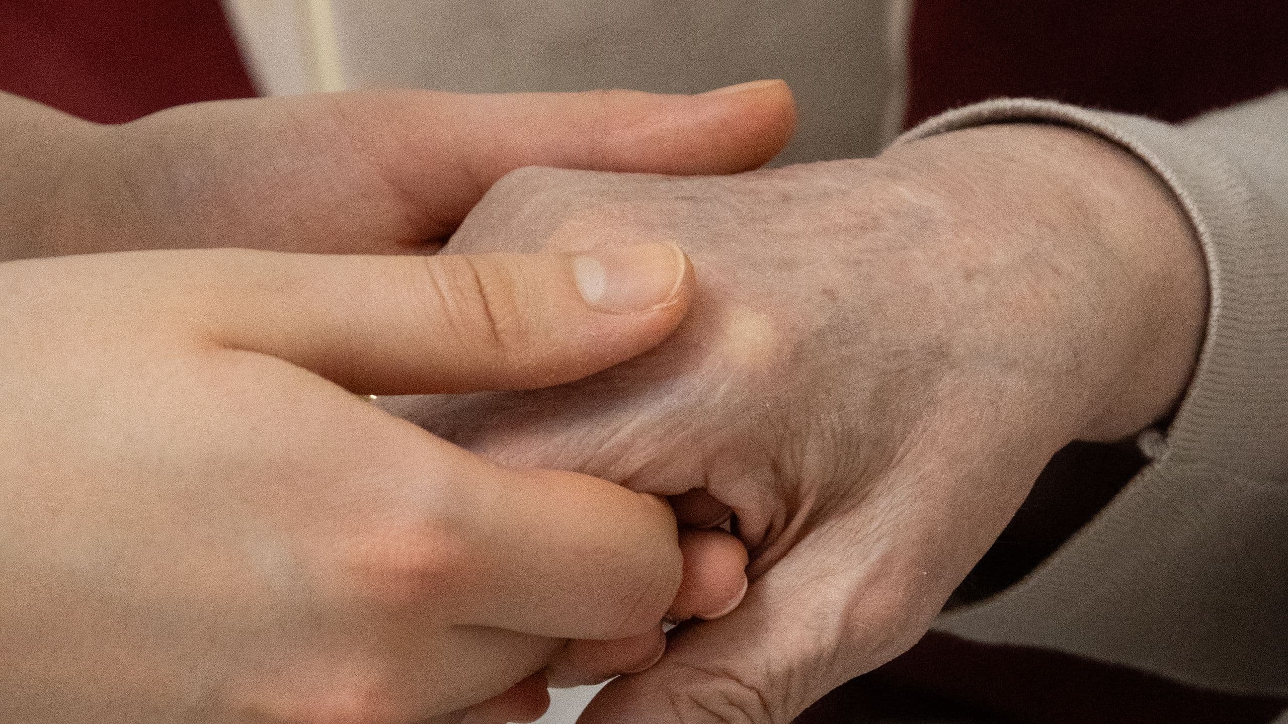 Une main plus jeune tenant la main d'une personne âgée, en signe de soutien.